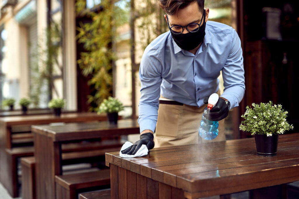 Man in mask cleaning tables - Restaurant Insurance, Hull